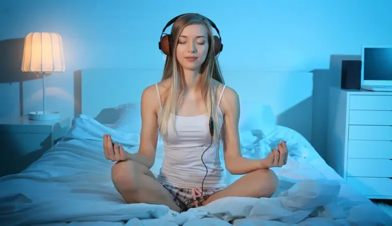 Junge Frau meditiert mit Musik